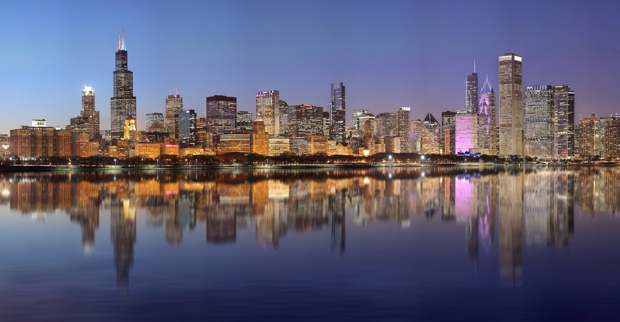 The Chicago skyline and lakefront at blue hour, reflected in Lake Michigan