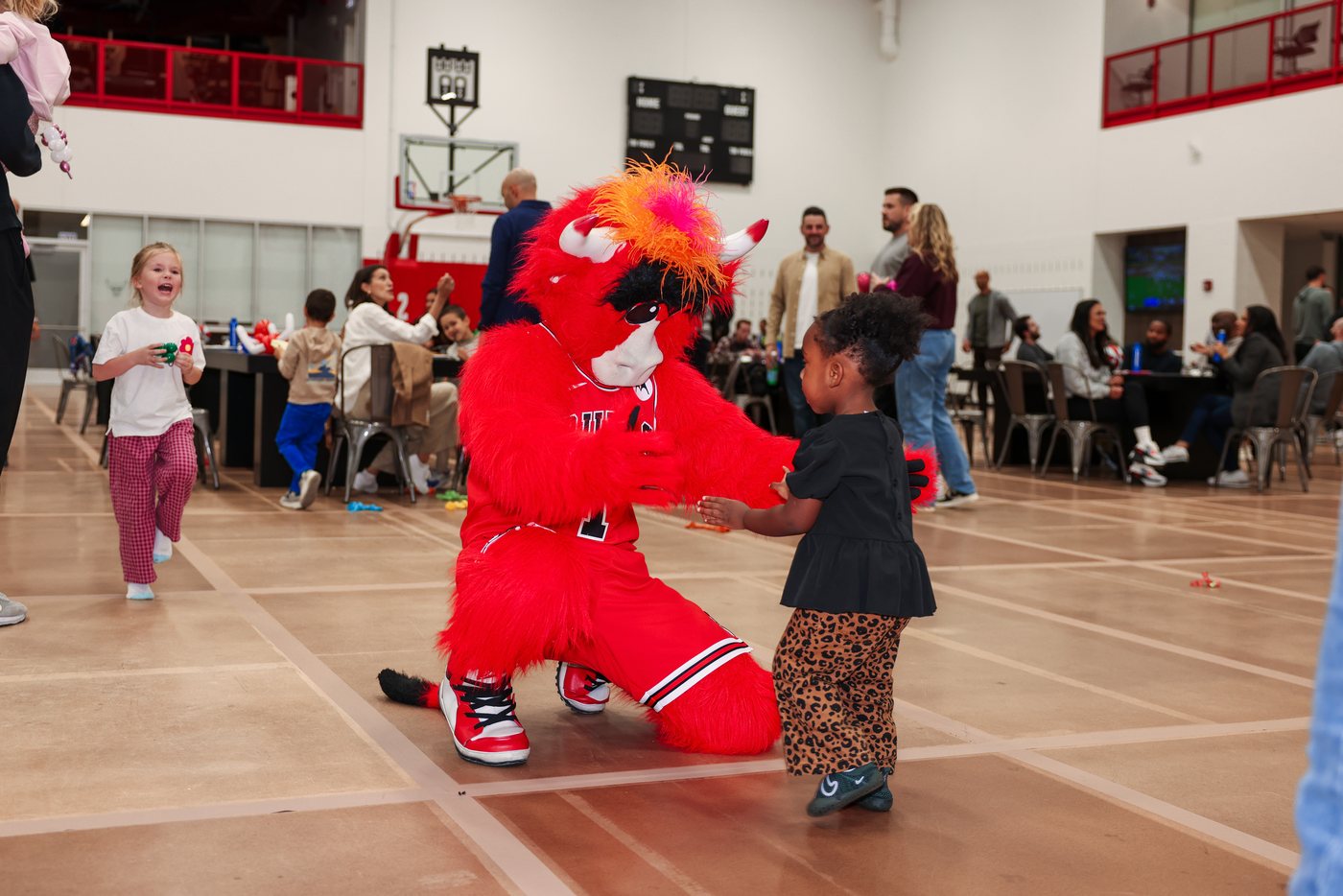 Benny the Bull greeting children at a Bulls family event on the practice court